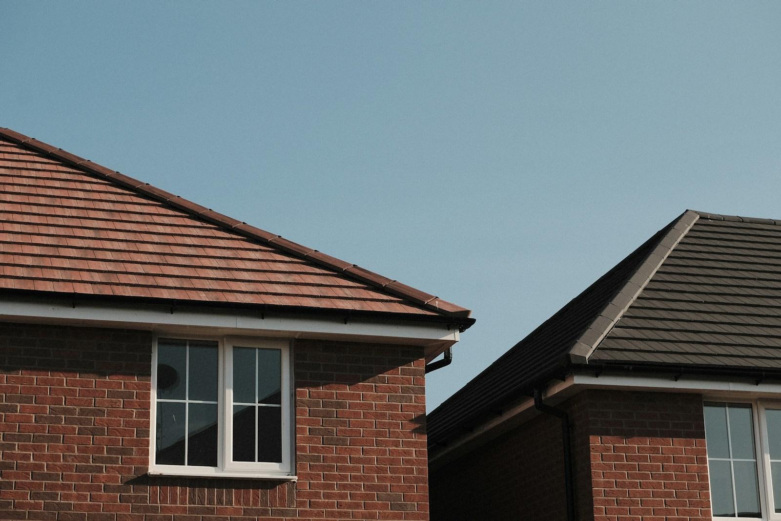 Twee bakstenen woningen met bruine pannendaken